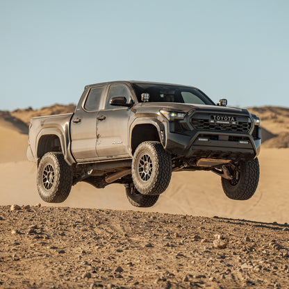 Toyota Tacoma with Dirt King DCA suspension jumping in desert